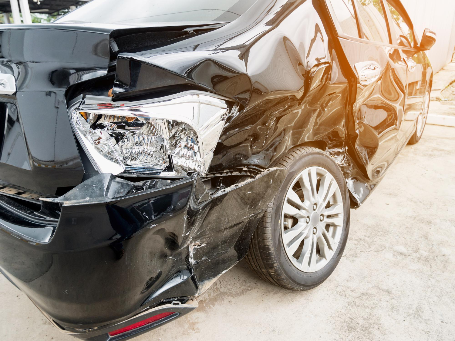 Front-end damage on a black car after a collision
